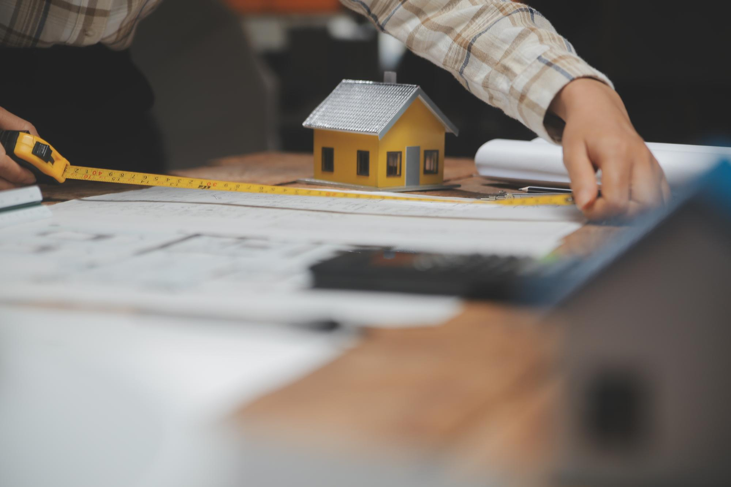 Équipe d'architectes multiethniques travaillant sur des plans de construction dans une salle de réunion